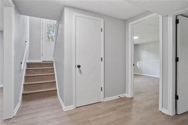 stairs with wood finished floors and baseboards
