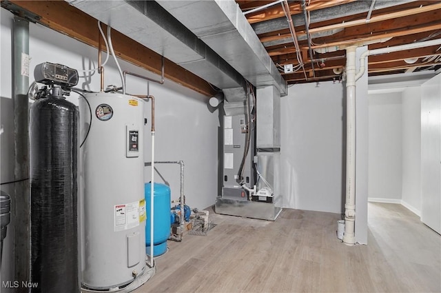 basement featuring a water pressure tank, electric water heater, wood finished floors, and heating unit