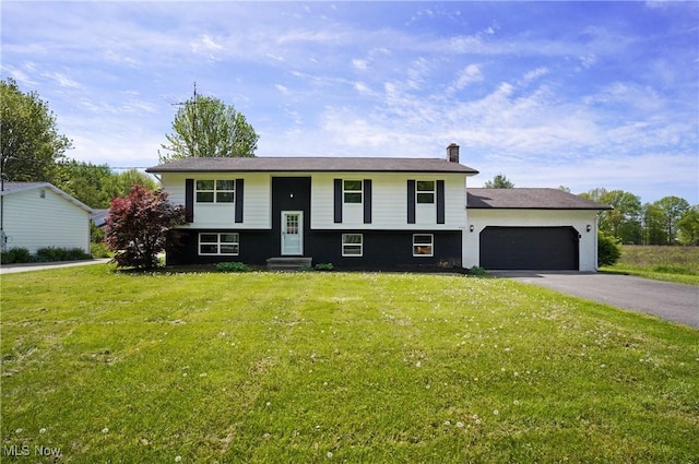 raised ranch with entry steps, asphalt driveway, a garage, a chimney, and a front lawn
