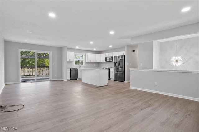 unfurnished living room with baseboards, recessed lighting, light wood-style flooring, and a sink