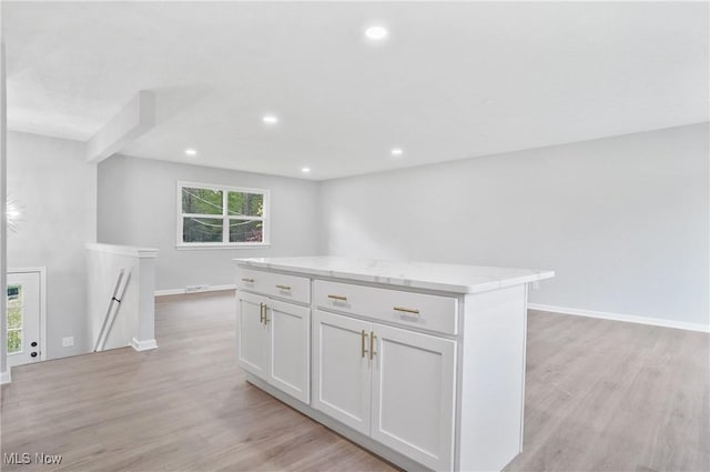 kitchen with a kitchen island, light wood-type flooring, white cabinets, recessed lighting, and baseboards