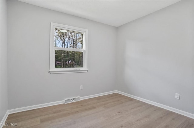 spare room with light wood-style flooring and baseboards