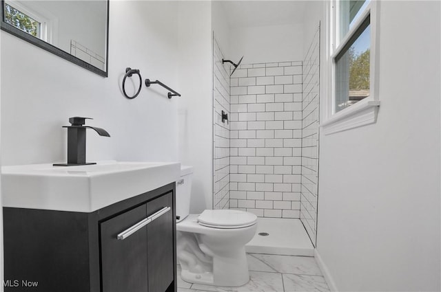 bathroom featuring marble finish flooring, a shower stall, toilet, vanity, and baseboards