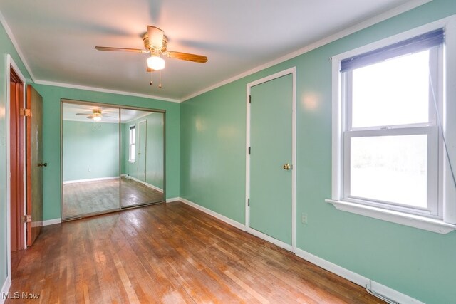 7026 S Boyden, Northfield, OH 44067 - unfurnished bedroom featuring wood-type flooring, baseboards, crown molding, a ceiling fan, and a closet