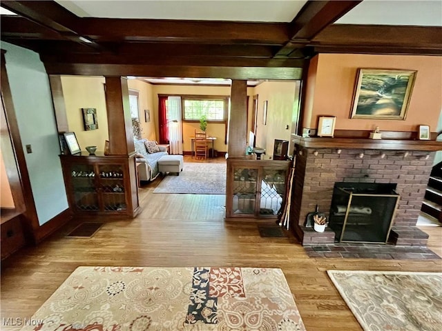 2508 Queenston Rd, Cleveland Heights, OH 44118 - living room featuring wood finished floors, beamed ceiling, a brick fireplace, baseboards, and coffered ceiling