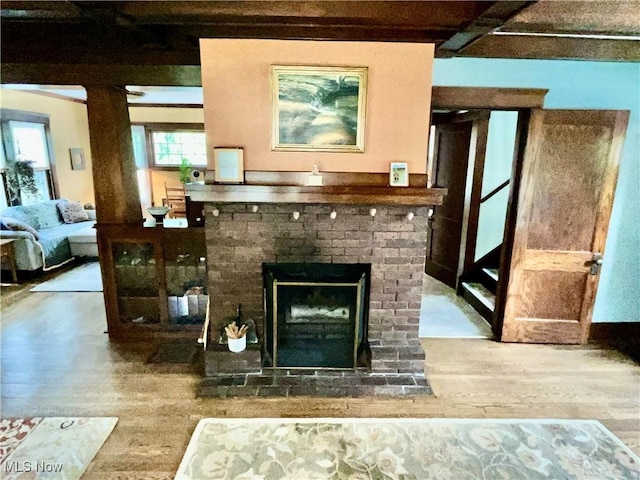 2508 Queenston Rd, Cleveland Heights, OH 44118 - living room with wood finished floors, beam ceiling, and a brick fireplace