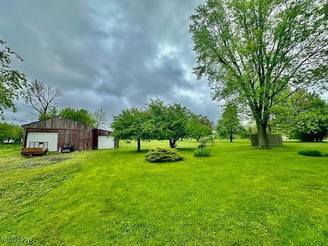 13053 Sarbaugh St SW, Navarre, OH 44662 - view of green lawn with an outdoor structure, a detached garage, and a pole building