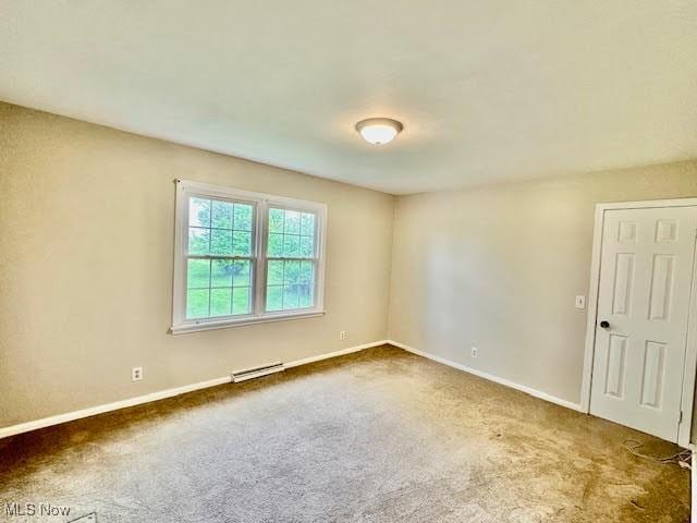 13053 Sarbaugh St SW, Navarre, OH 44662 - spare room with carpet floors, baseboards, and a baseboard heating unit