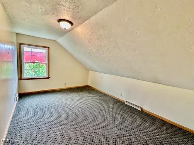 13053 Sarbaugh St SW, Navarre, OH 44662 - bonus room with a textured ceiling, vaulted ceiling, baseboards, and carpet floors