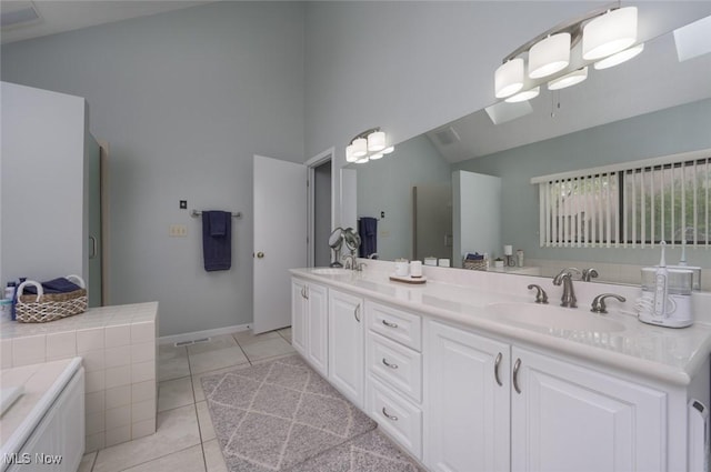 full bath with high vaulted ceiling, tile patterned flooring, double vanity, baseboards, and a bathtub