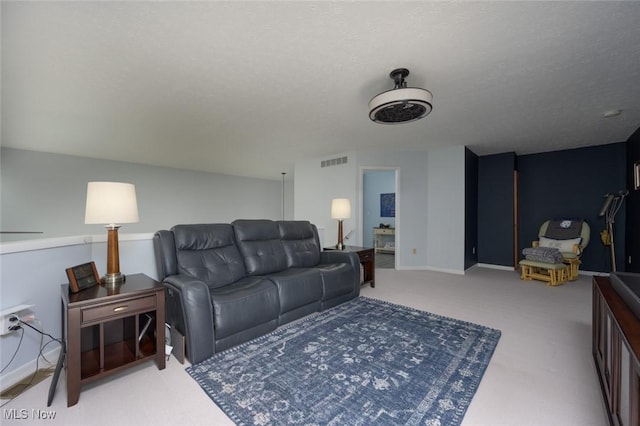 carpeted living area featuring a textured ceiling
