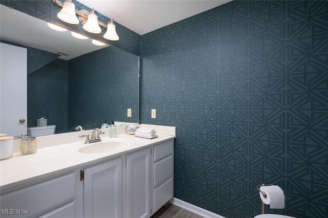 half bath featuring vanity and toilet