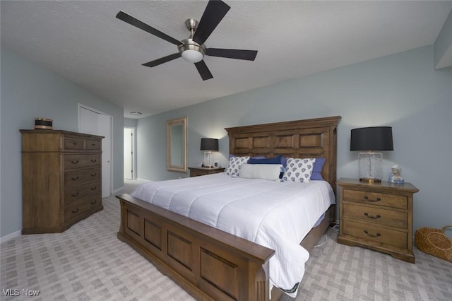 bedroom with light carpet, a ceiling fan, and baseboards
