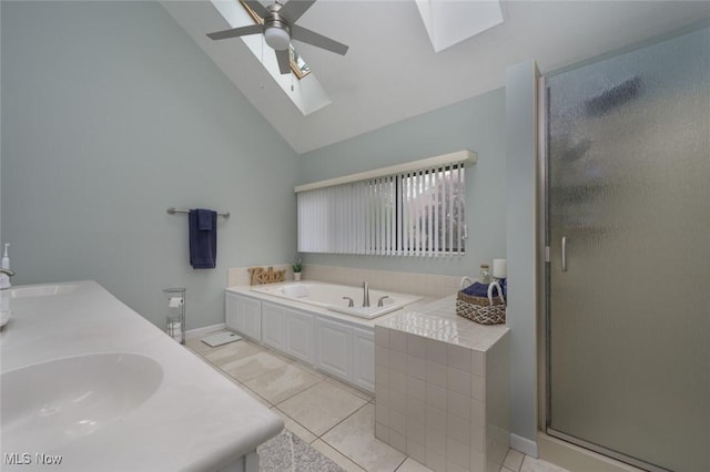 full bath featuring a skylight, a shower stall, a garden tub, high vaulted ceiling, and ceiling fan