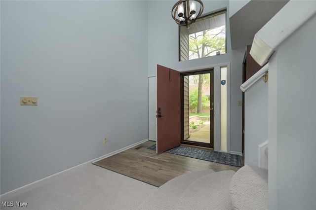foyer featuring a chandelier, a high ceiling, and wood finished floors