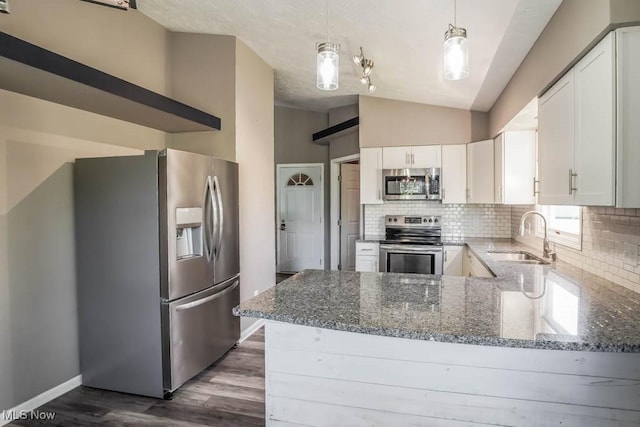 5291 Francesca St NE, Louisville, OH 44641 - kitchen with appliances with stainless steel finishes, a sink, tasteful backsplash, a peninsula, and vaulted ceiling