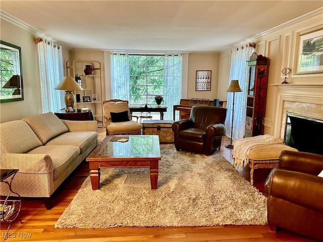 living room with ornamental molding, wood finished floors, healthy amount of natural light, and a premium fireplace