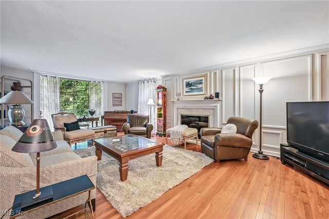 3711 Sampson Rd, Youngstown, OH 44505 - living area featuring a decorative wall, wood-type flooring, and a glass covered fireplace
