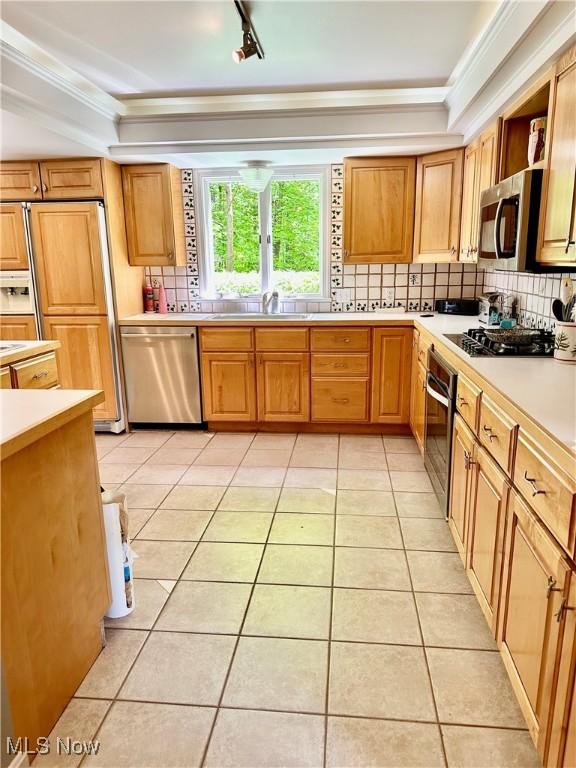 3711 Sampson Rd, Youngstown, OH 44505 - kitchen featuring appliances with stainless steel finishes, ornamental molding, tasteful backsplash, light countertops, and light tile patterned flooring