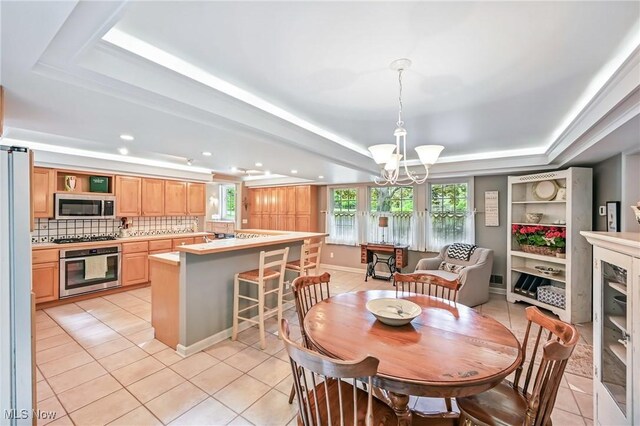 3711 Sampson Rd, Youngstown, OH 44505 - dining area featuring a tray ceiling, a chandelier, light tile patterned flooring, and recessed lighting