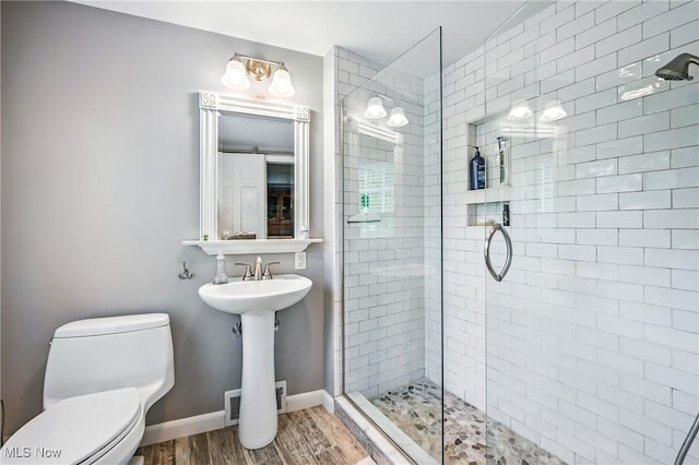 3711 Sampson Rd, Youngstown, OH 44505 - full bathroom featuring a tile shower, wood finished floors, toilet, and baseboards