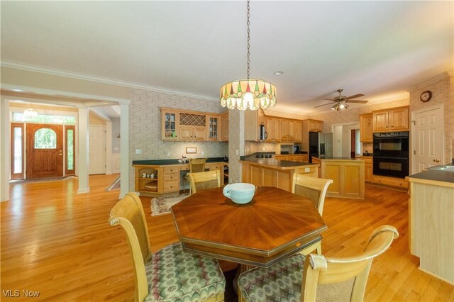 1030 Whisperwood Ln, Aurora, OH 44202 - dining area featuring light wood finished floors, crown molding, wallpapered walls, and a ceiling fan