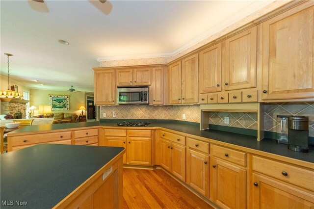 1030 Whisperwood Ln, Aurora, OH 44202 - kitchen with stainless steel microwave, dark countertops, ceiling fan, wood finished floors, and crown molding