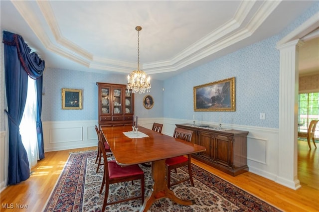 1030 Whisperwood Ln, Aurora, OH 44202 - dining area featuring light wood-type flooring, a chandelier, a tray ceiling, crown molding, and wainscoting