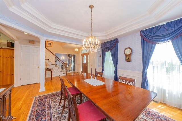 1030 Whisperwood Ln, Aurora, OH 44202 - dining space featuring stairway, a chandelier, ornamental molding, light wood-style flooring, and a raised ceiling