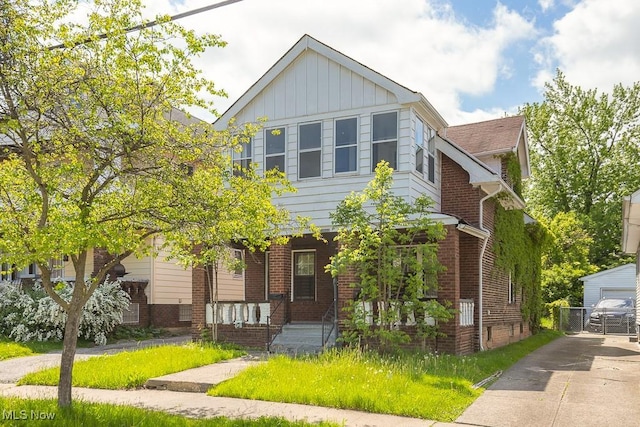 11002 Greenwich Ave, Cleveland, OH 44105 - view of front of house with brick siding, a porch, and board and batten siding
