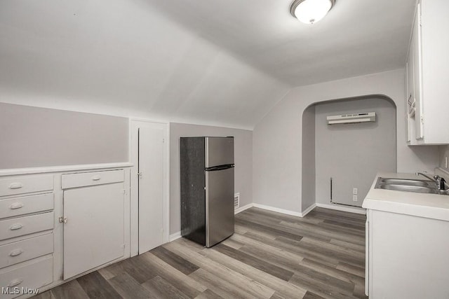 11002 Greenwich Ave, Cleveland, OH 44105 - washroom with a sink, wood finished floors, an AC wall unit, and baseboards