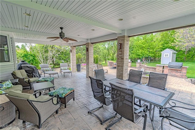 view of patio featuring outdoor dining space, a storage unit, an outbuilding, a ceiling fan, and an outdoor hangout area