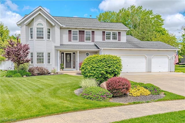 traditional-style home featuring driveway, a garage, and a front yard