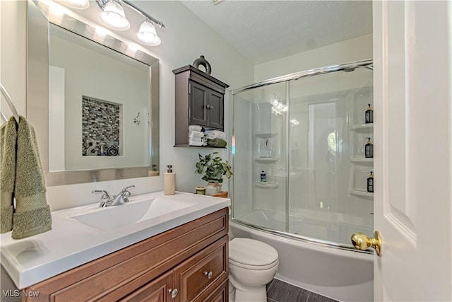 full bath with toilet, vanity, and bath / shower combo with glass door