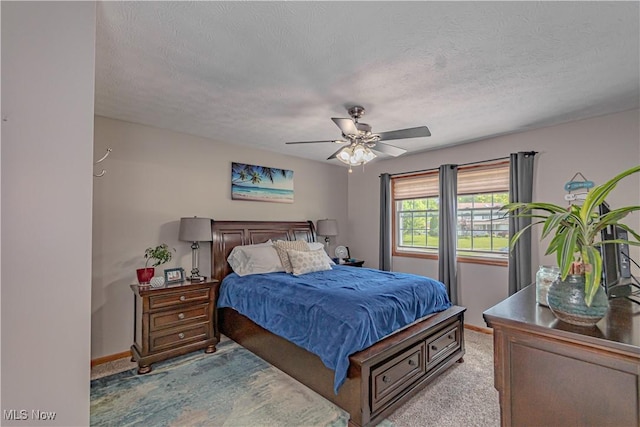 bedroom with light colored carpet, baseboards, a textured ceiling, and ceiling fan
