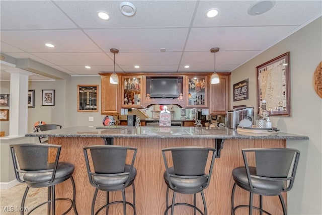 indoor wet bar featuring a paneled ceiling, hanging light fixtures, recessed lighting, and stove