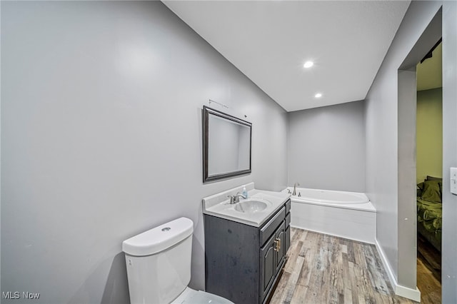 4946 Ireland Rd, Rome, OH 44085 - full bath with wood finished floors, toilet, a garden tub, vanity, and recessed lighting