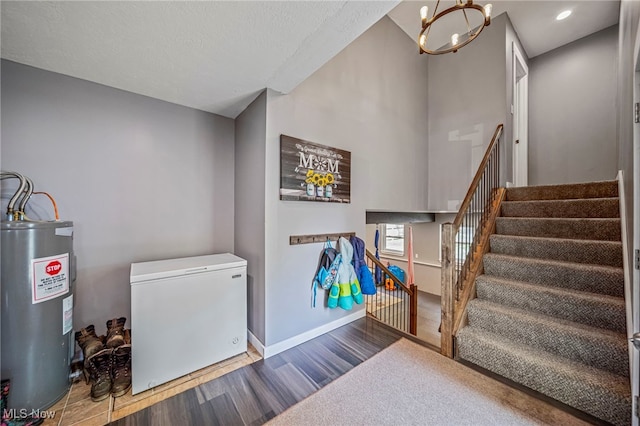 4946 Ireland Rd, Rome, OH 44085 - stairway with water heater, wood finished floors, a chandelier, and baseboards