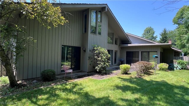 250 Laurel Cir Unit 13, Aurora, OH 44202 - rear view of property featuring a lawn and a chimney