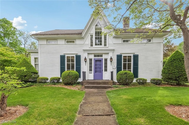 view of front of property with a front yard and a chimney