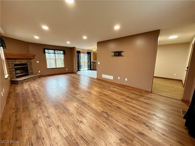 36 Choctaw Trl, Malvern, OH 44644 - unfurnished living room featuring light wood finished floors, recessed lighting, baseboards, and a fireplace
