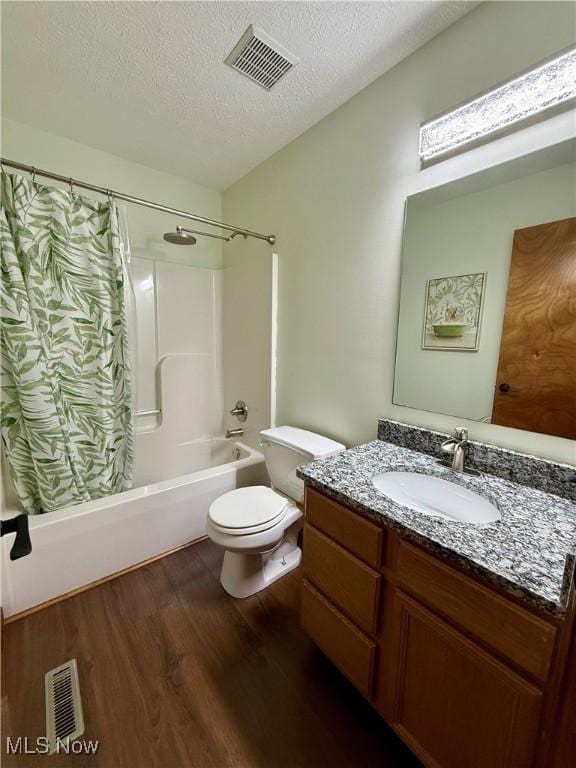 36 Choctaw Trl, Malvern, OH 44644 - bathroom featuring wood finished floors, a textured ceiling, shower / tub combo, toilet, and vanity