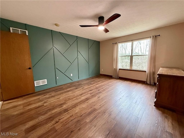 36 Choctaw Trl, Malvern, OH 44644 - empty room featuring a ceiling fan, wood finished floors, baseboards, and a textured ceiling