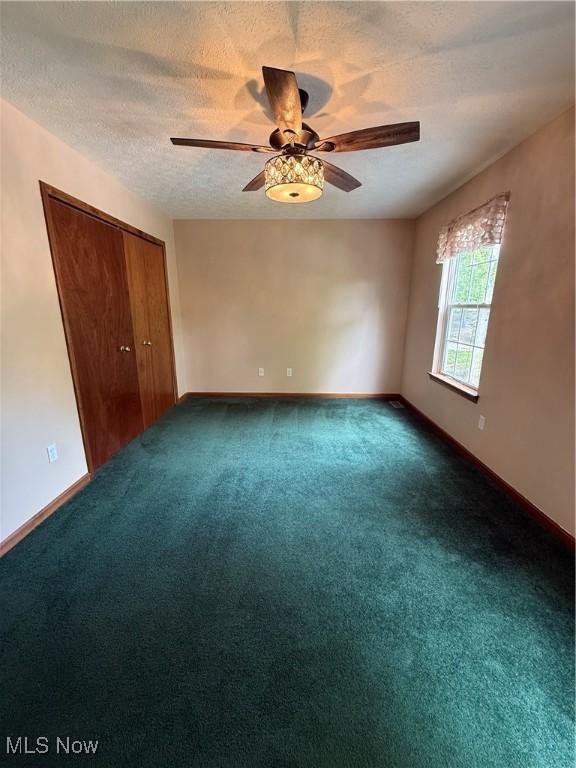 36 Choctaw Trl, Malvern, OH 44644 - unfurnished bedroom with carpet floors, baseboards, a textured ceiling, a closet, and a ceiling fan