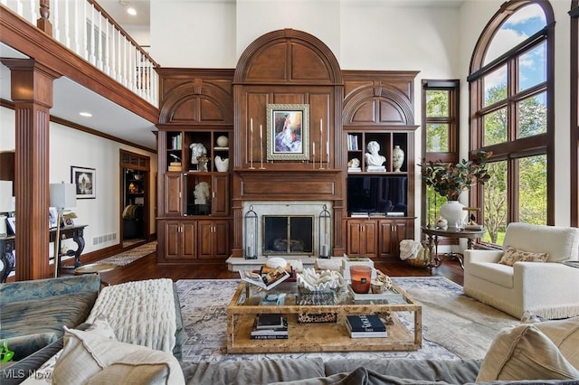 7384 Braucher St NW, North Canton, OH 44720 - living room featuring a high ceiling, dark wood-style flooring, a high end fireplace, baseboards, and ornate columns