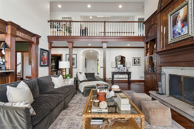 7384 Braucher St NW, North Canton, OH 44720 - living room with ornate columns, a high ceiling, a high end fireplace, dark wood finished floors, and arched walkways