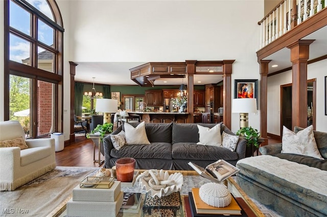 7384 Braucher St NW, North Canton, OH 44720 - living room featuring a high ceiling, ornate columns, dark wood finished floors, and a chandelier