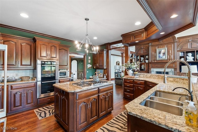 7384 Braucher St NW, North Canton, OH 44720 - kitchen with appliances with stainless steel finishes, a sink, a center island, backsplash, and dark wood-style floors