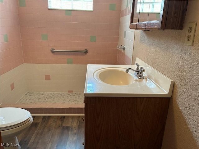 260 Miller Ave, Weirton, WV 26062 - bathroom featuring wood finished floors, tiled shower, a textured wall, toilet, and vanity