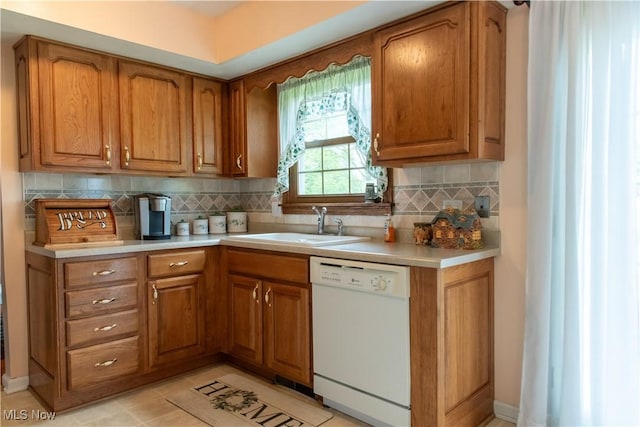 7969 Bricker Rd NW, Massillon, OH 44646 - kitchen with dishwasher, brown cabinetry, light countertops, and decorative backsplash